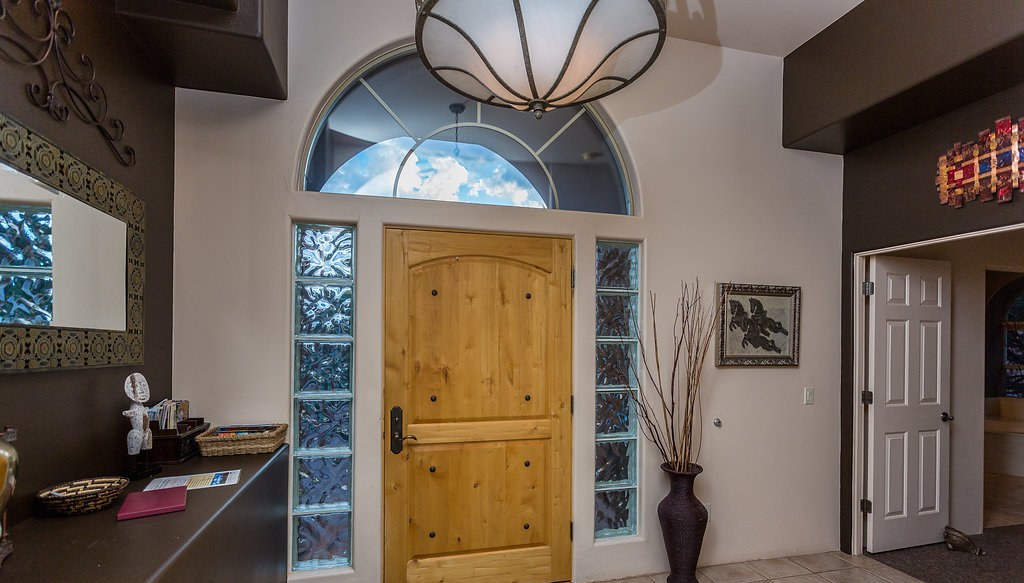 Arched entry foyer with wood door